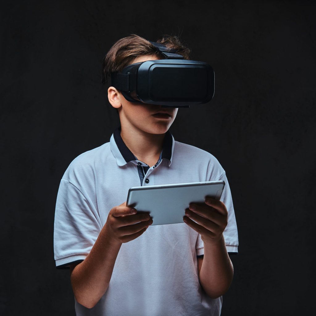Teenager using vr. Isolated on the dark background.